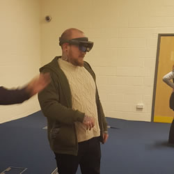 A picture of a student using the Microsoft Holo Lens at the Work in Tech presentation.