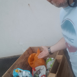 Wheeling a trolley full of donations from the dropoff point at the nearby Hope Cafe to be processed at the food bank.
